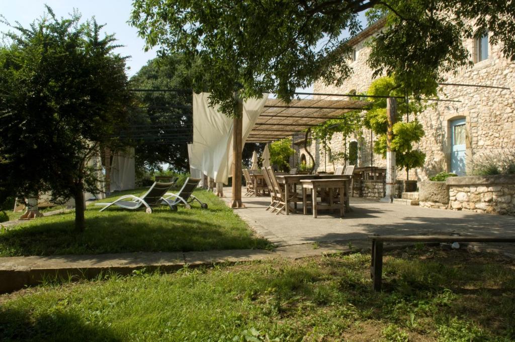a patio with a table and chairs in a yard at Comptoir Saint-Hilaire in Saint-Hilaire-de-Brethmas