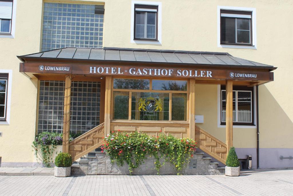a hotel cashierierieraza with flowers in front of a building at Hotel und Gasthof Soller in Ismaning