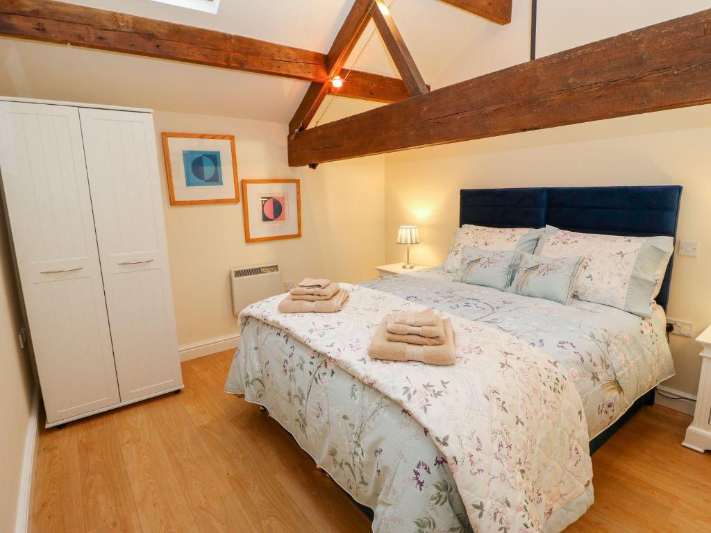 a bedroom with a bed with two towels on it at The Loft Apartment in Todmorden