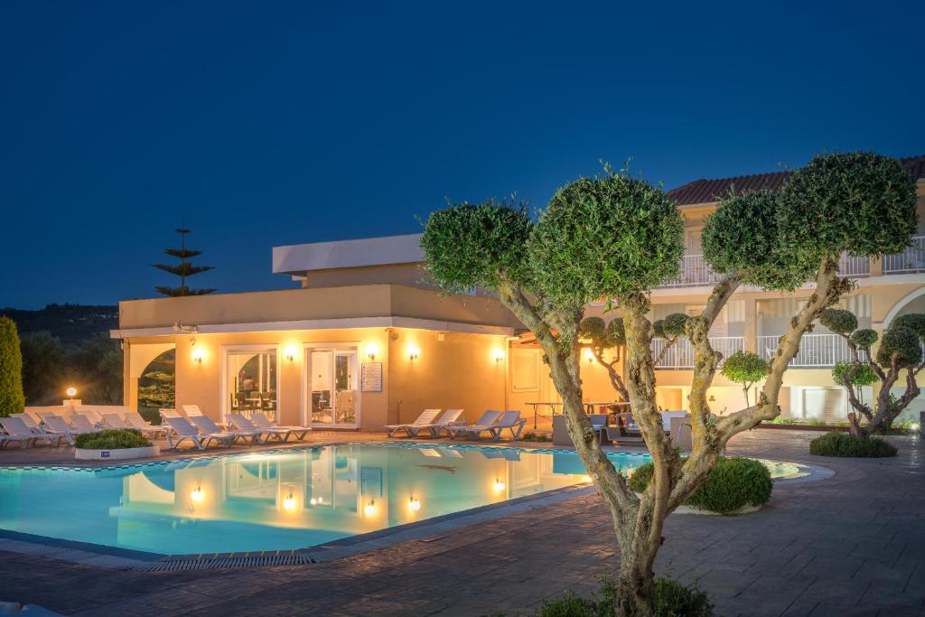 a swimming pool in front of a building at night at Filoxenia Hotel Zakynthos in Tsilivi