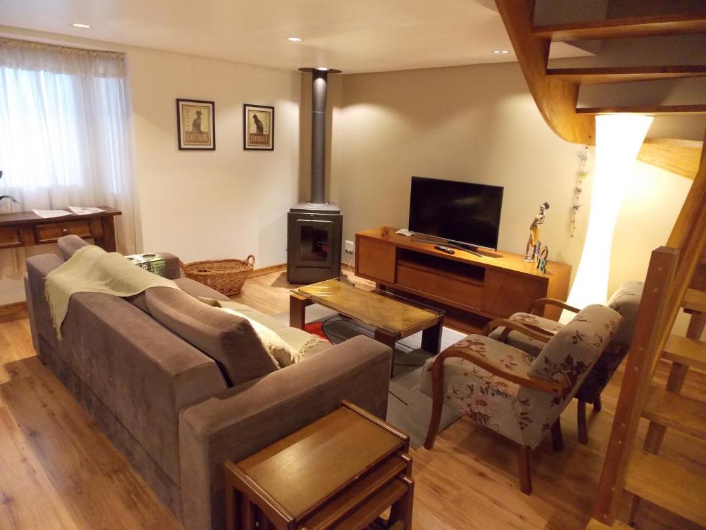 a living room with a couch and a stove at Triplex 3 suítes em Canela in Canela