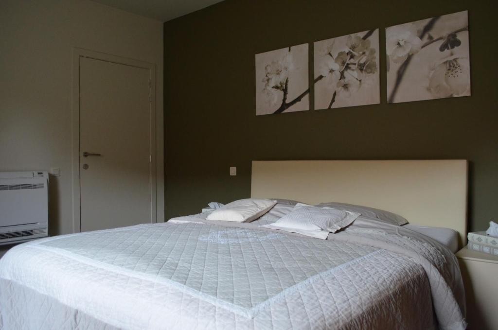 1 dormitorio con 1 cama blanca y 2 almohadas en B&B Hof Ter Haegen en Vollezele