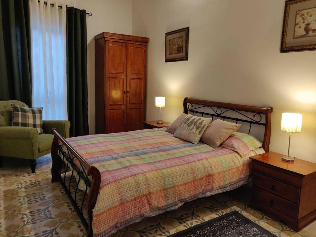 Tarxien的住宿－Rons Town House，一间卧室配有一张床和一把椅子