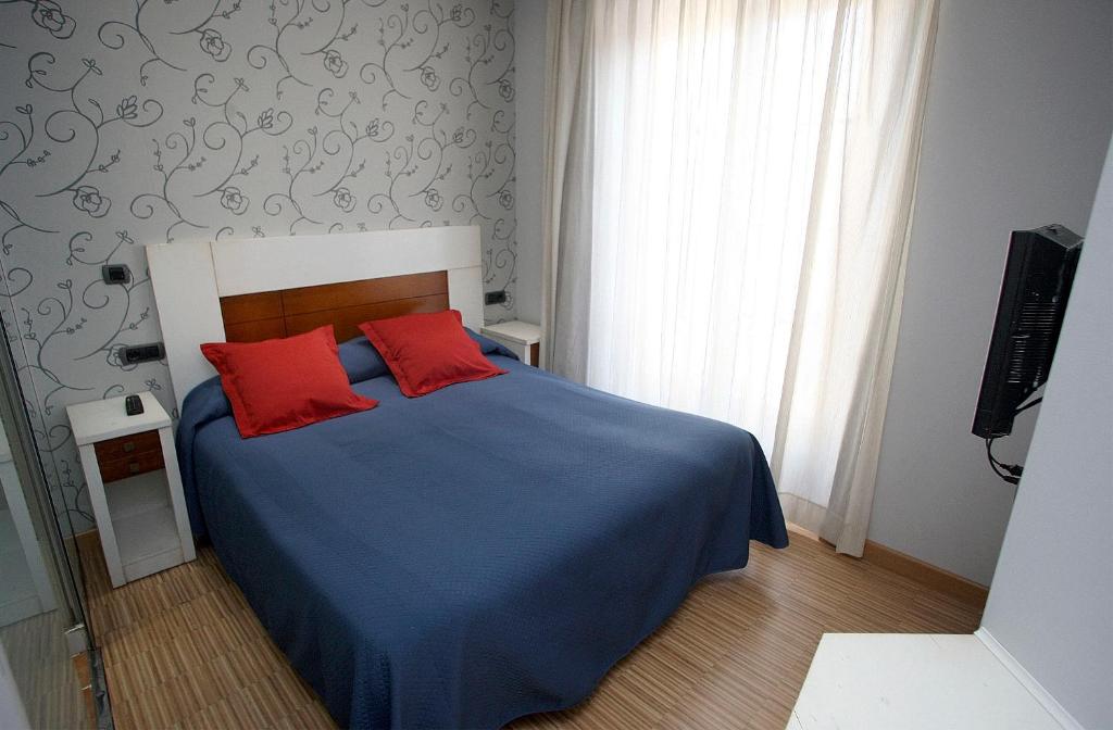 A bed or beds in a room at Hostal Centro