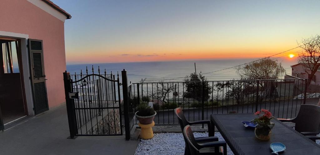 een balkon met uitzicht op de oceaan bij zonsondergang bij Casa vacanze Osvaldo in San Bernardino