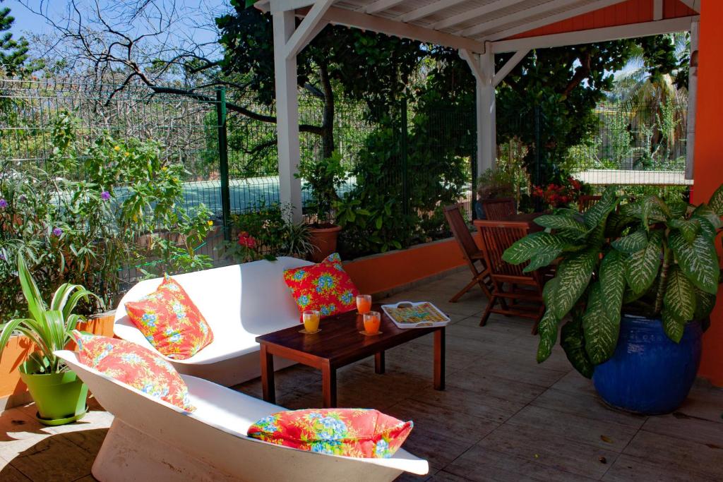 un patio con un sofá blanco y una mesa en le Cocon, en Le Moule
