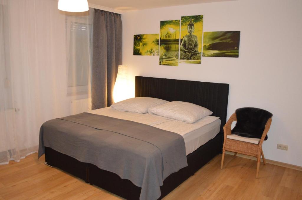 ニュルンベルクにあるModernes 1-Zimmer Apartment W-Lan, Stellplatzのベッドルーム1室(ベッド1台、椅子、壁に絵画付)