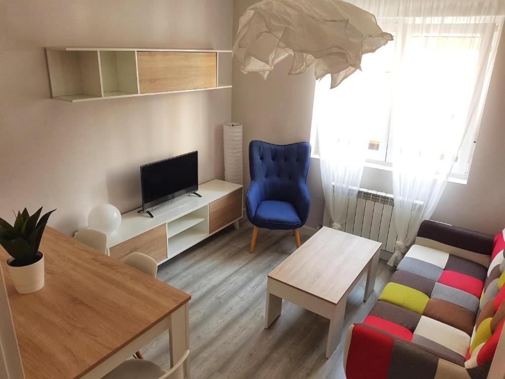 a living room with a blue chair and a television at PISO TURÍSTICO MAGA - LUXURY FLOOR IDEAL FAMILIAS in Zamora