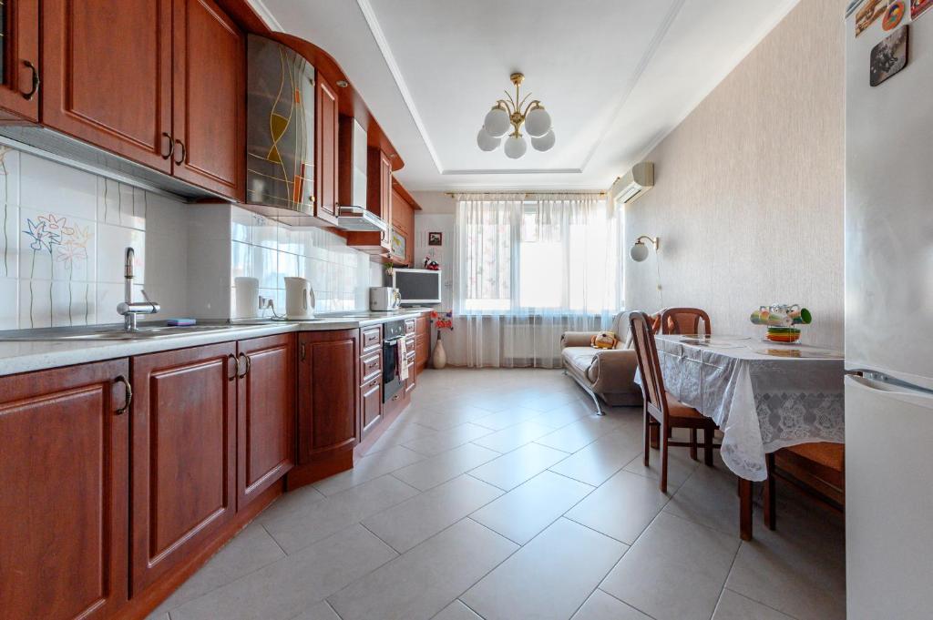 - une cuisine avec des placards en bois et une table dans l'établissement Happy Time, à Odessa