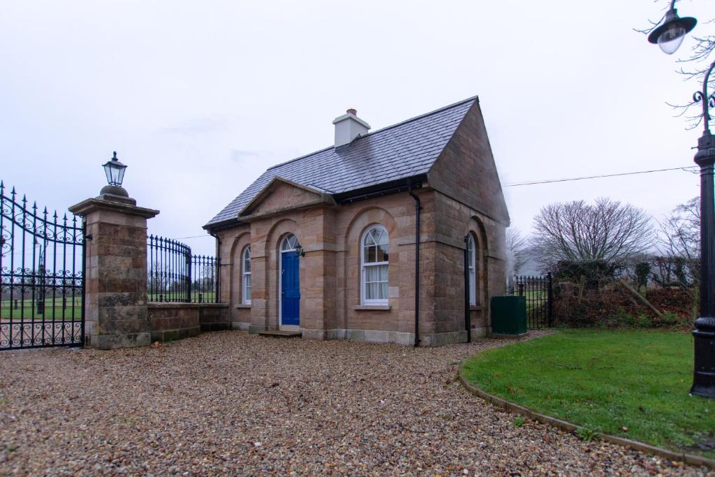 un piccolo edificio in mattoni con una porta blu di The Gatelodge a Dungiven