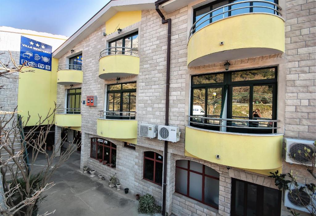 a building with yellow balconies on the side of it at Guest house Mediteran Relax in Makarska