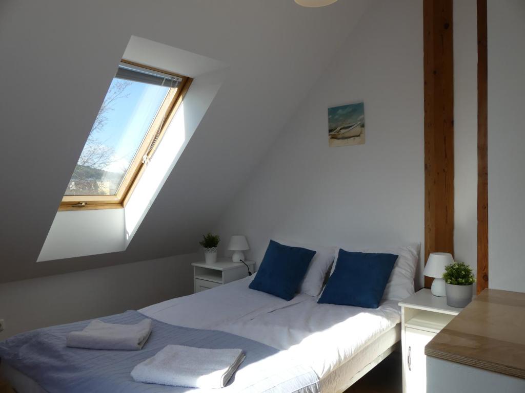 a bedroom with a bed with blue pillows and a window at Apartament Pola & Tola in Sopot