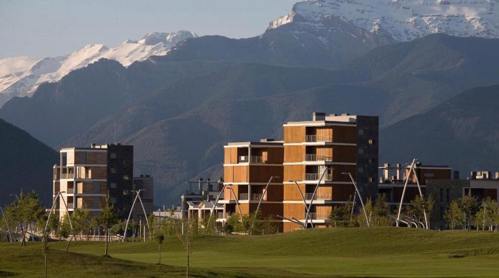 una ciudad con edificios y montañas en el fondo en Destino Deluxe Pirineos, en Sabiñánigo