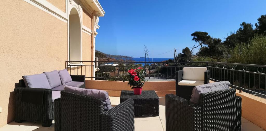 a balcony with two chairs and a table with flowers at Résidence Robinson Standing Pieds dans l'eau in Agay - Saint Raphael