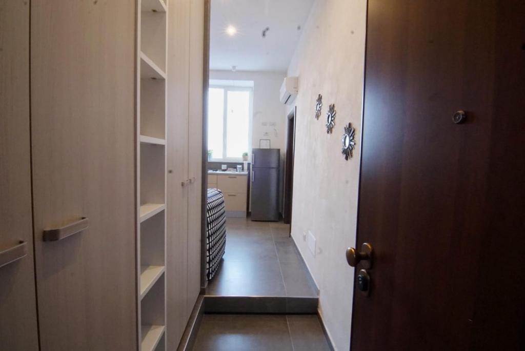 a hallway with a door and a kitchen with a refrigerator at Holiday House in Naples