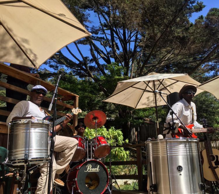 a band playing drums under an umbrella at Big Sur River Inn in Big Sur