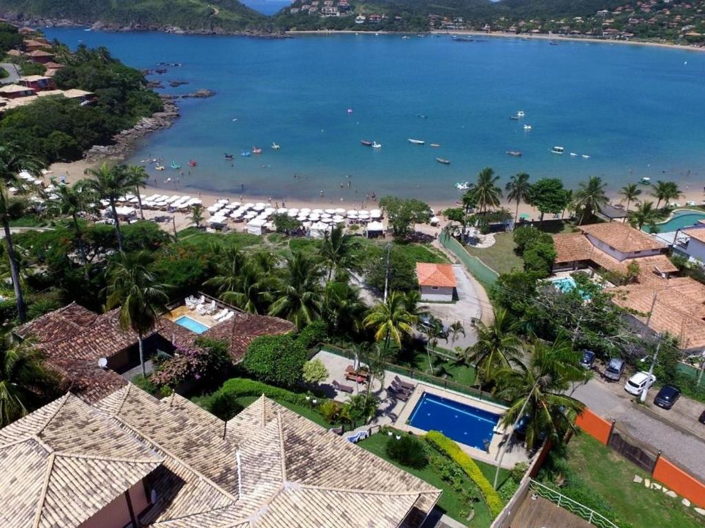 z anteny widok na plażę z palmami i domami w obiekcie Mansão Cinematográfica de Frente para à Praia da Ferradura com Sete Suítes Por Luxury Rentals w mieście Búzios