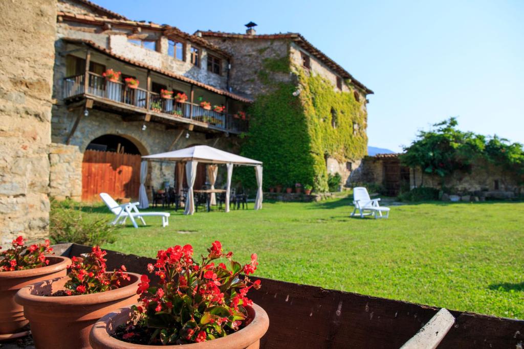 a garden with flowers in pots in front of a building at Masia La Canal in Gombreny