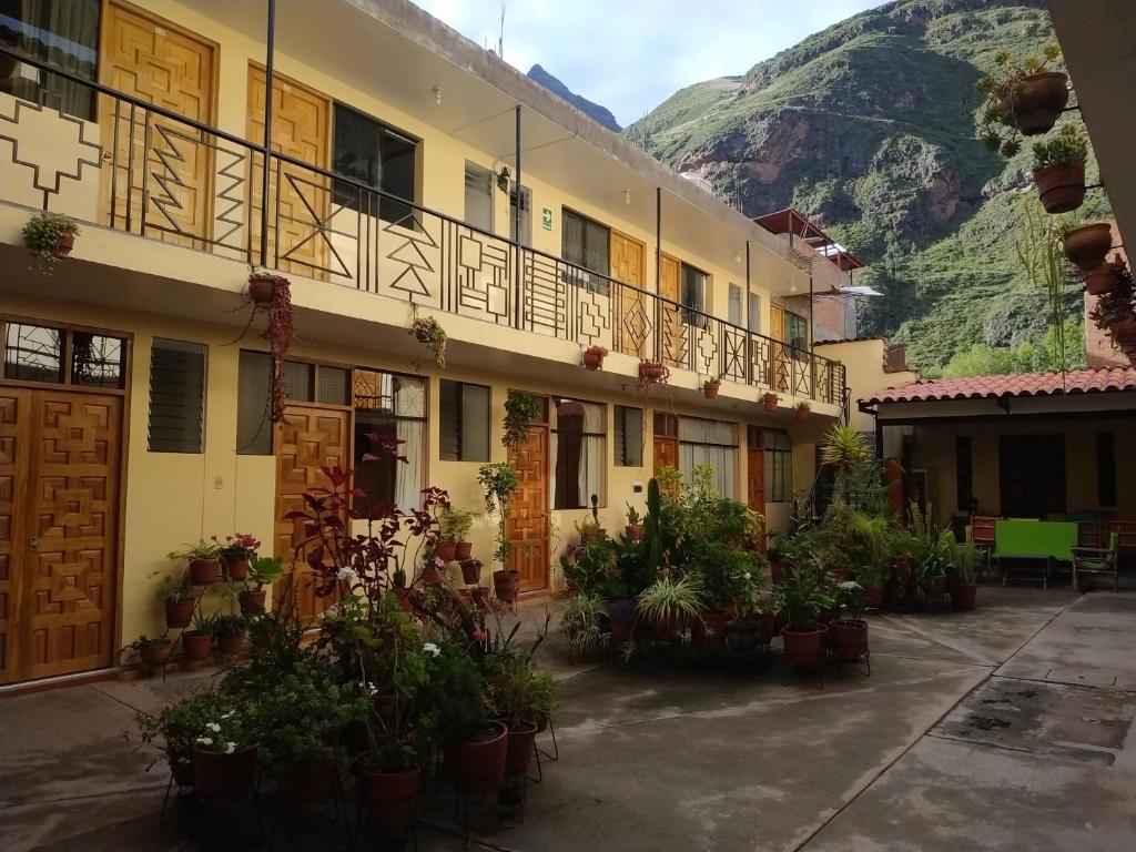 een gebouw met planten op een binnenplaats met een berg bij Hospedaje Inti in Pisac