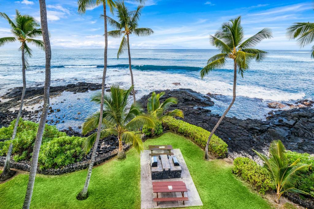 z góry widok na ośrodek z palmami i ocean w obiekcie Oceanfront Luxury Condo w mieście Kailua-Kona