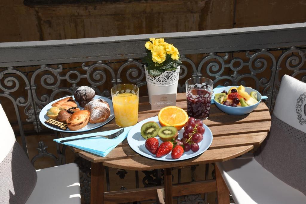 una mesa con platos de comida y fruta en el balcón en Miro B&B en Lecce
