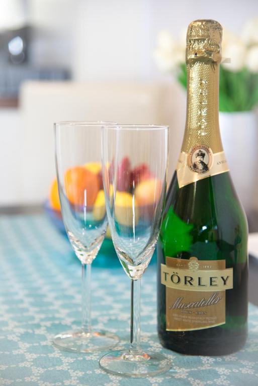 a bottle of champagne and two glasses on a table at Mirage Apartments Váci Street in Budapest