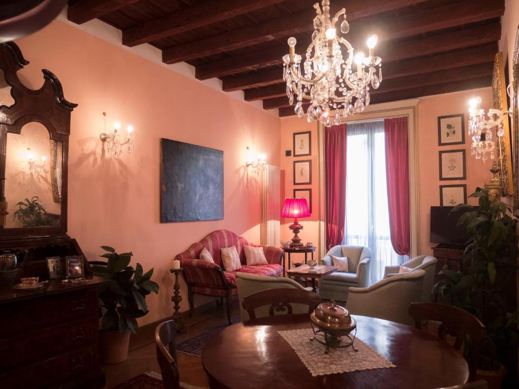 a living room with a chandelier and a table and chairs at Broletto 26 in Milan