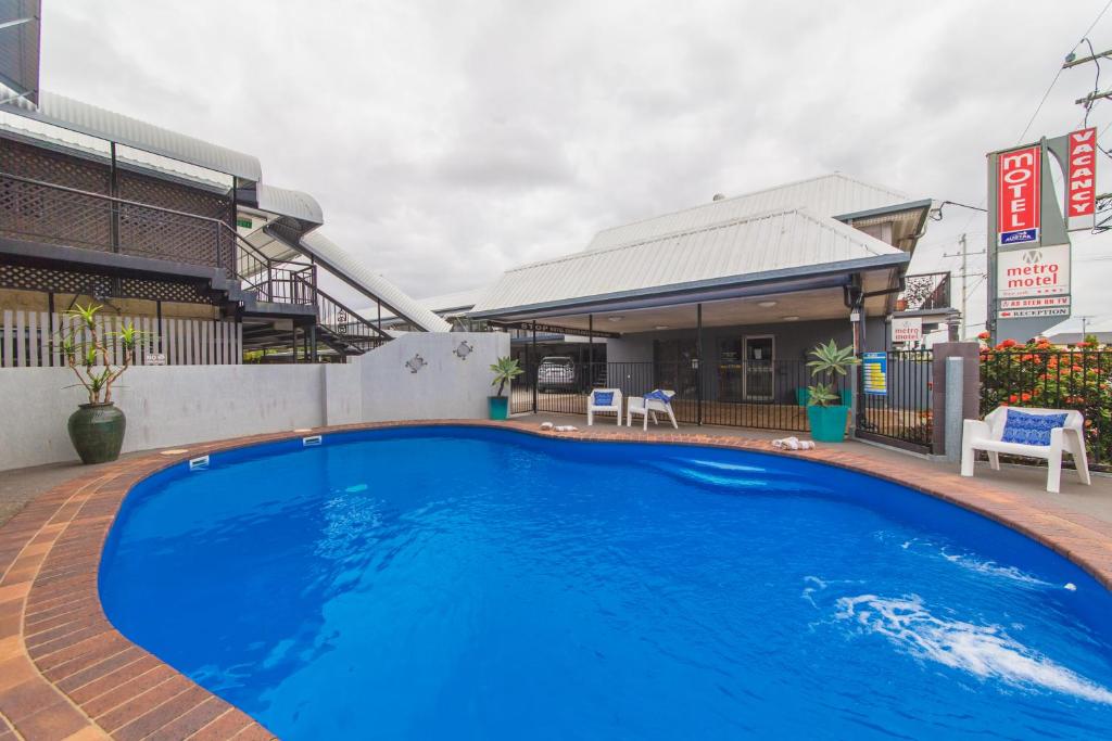 a large blue swimming pool in front of a building at Metro Motel Rockhampton in Rockhampton