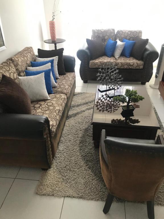 a living room with two couches and a table at Ave. Duarte k3/12, Residencial Palma Real, Santiago, RD in Arenoso