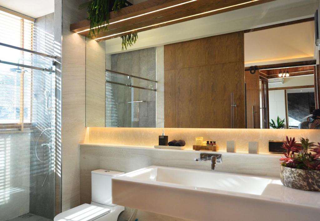 a bathroom with a sink and a toilet and a mirror at The Cabin Beach Resort in Haad Rin