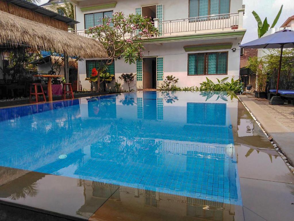 a swimming pool in front of a house at Damnak Riverside Villa in Siem Reap