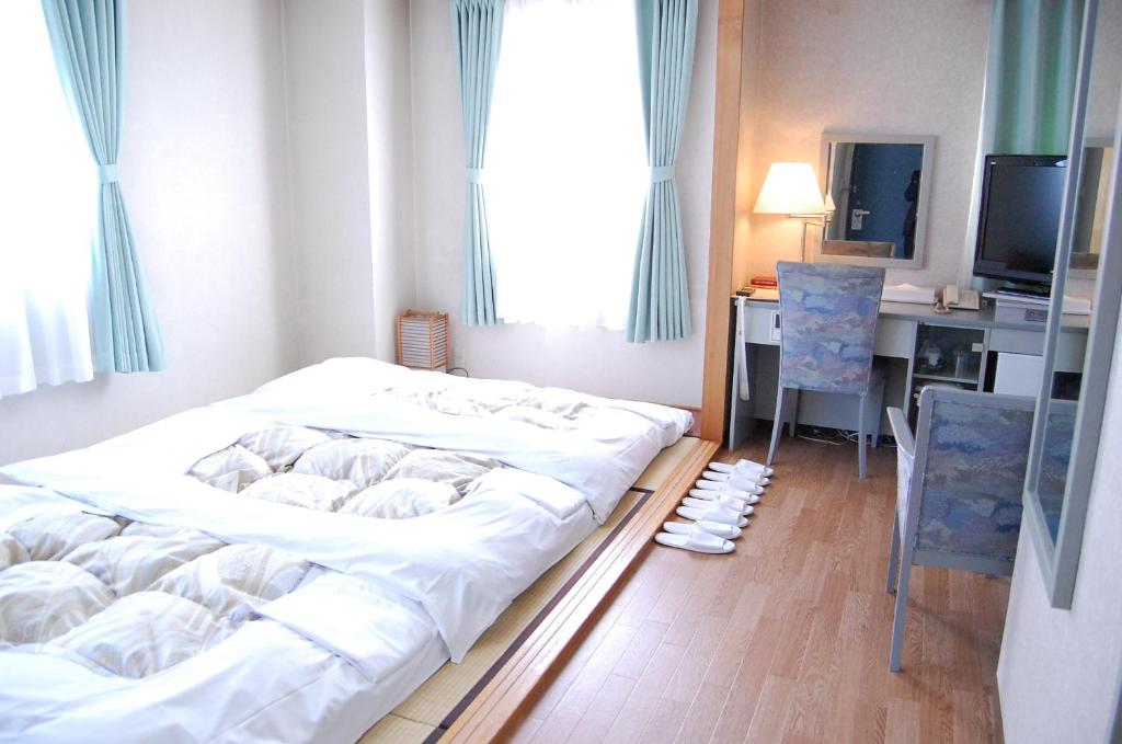 Postel nebo postele na pokoji v ubytování Seagrande Shimizu Station Hotel
