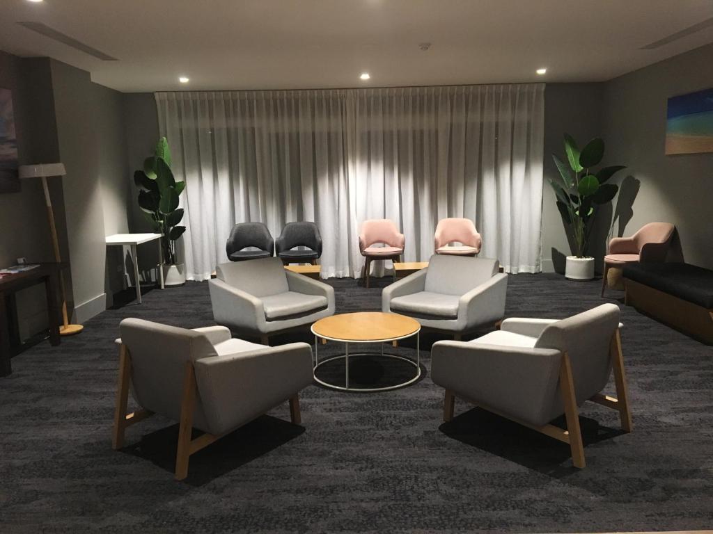 a living room filled with furniture and a table at Woodroffe Hotel in Gold Coast