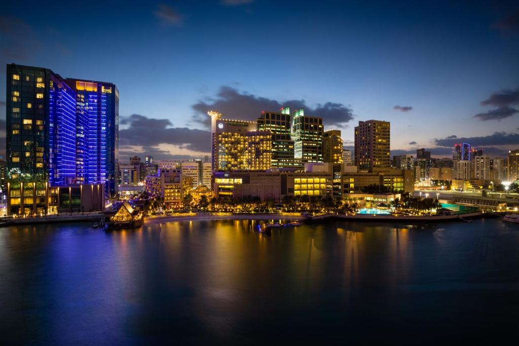 a city skyline at night with a river and buildings at Beach Rotana - Abu Dhabi in Abu Dhabi