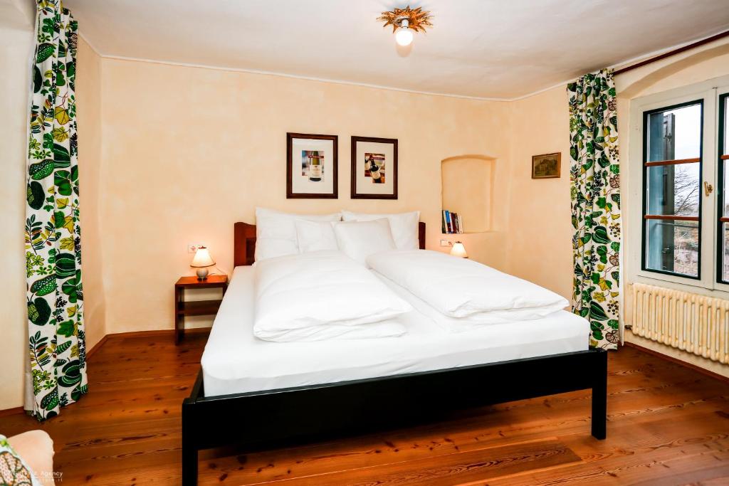 a bedroom with a large white bed with white pillows at Weinbergsuite Panholzer in Caldaro