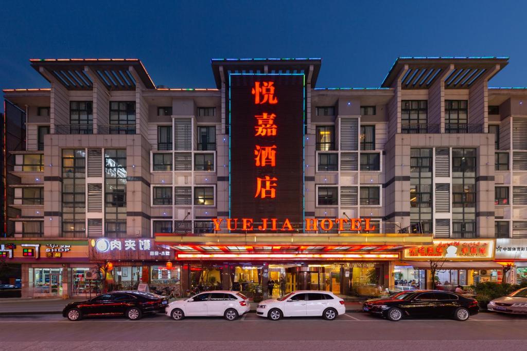 义乌义乌悦嘉商务宾馆的一群汽车停在一栋建筑物前
