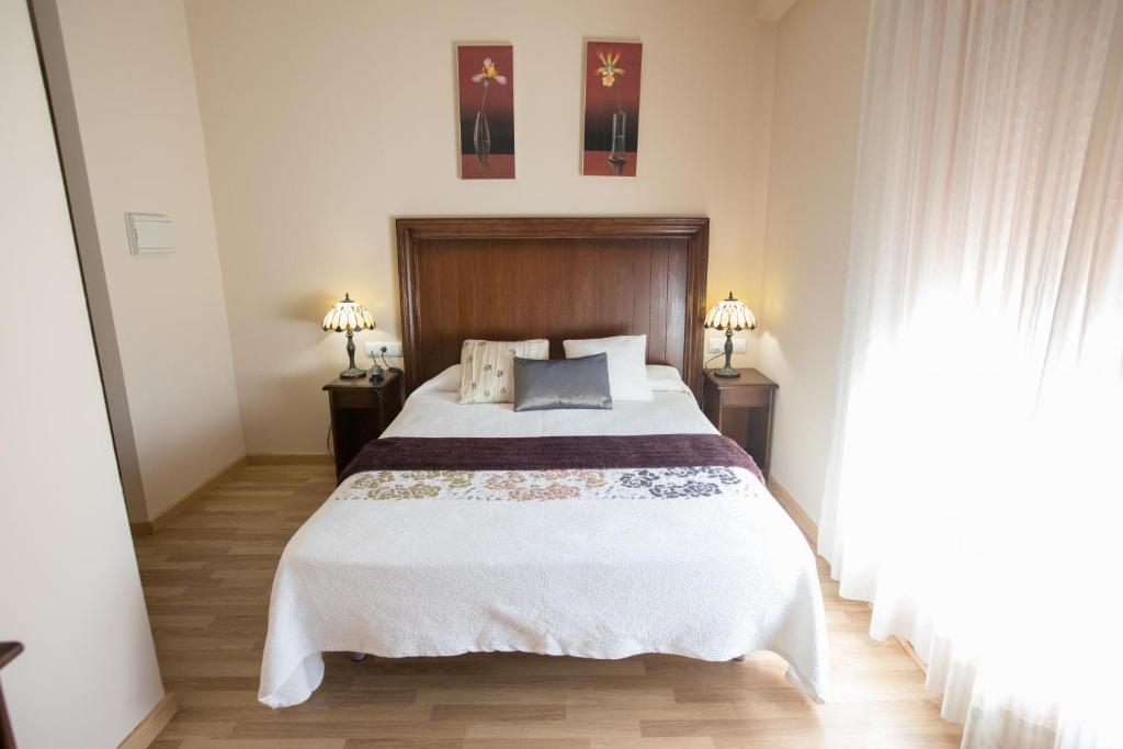 Hotel Arcco Ubeda في أوبيذا: غرفة نوم بسرير كبير ومصباحين