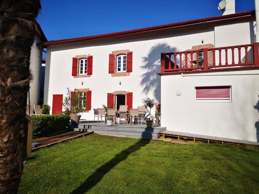 a white house with red shutters and a yard at Chalbonia in Louhossoa