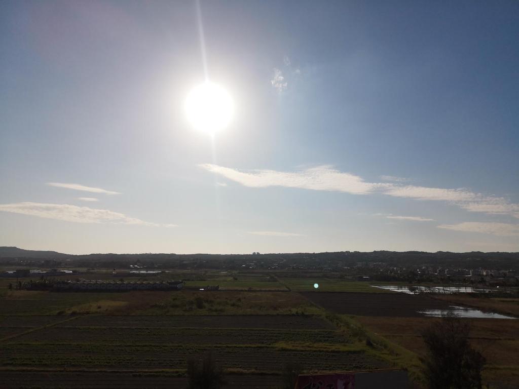 a view of a field with the sun in the sky at 墾丁秋莊會館 附限量停車位 不保證有位置 無法事先預留 背包房無車位 預訂後記得加Line聯繫 in Hengchun