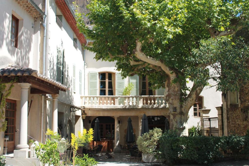 a white house with a tree in front of it at Le Manoir in Mornas