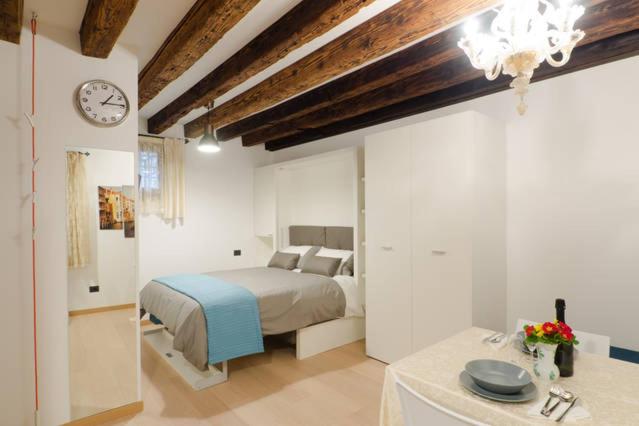 ヴェネツィアにあるSan Marco Luxury Studioのベッドルーム1室(ベッド1台、壁掛け時計付)
