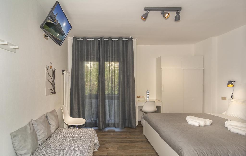 sypialnia z łóżkiem, kanapą i oknem w obiekcie BB L'APPRODO w Pizie