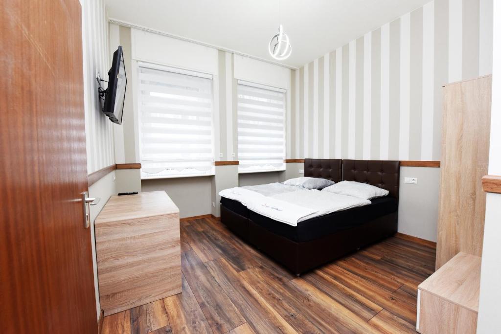 1 dormitorio con 1 cama, TV y ventana en Design Apartments 2 en Dortmund
