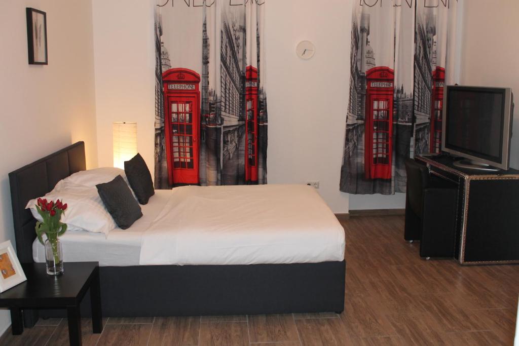 ウィーンにあるUrban-Style-Studioのベッドルーム1室(ベッド1台、テレビ、赤い電話ブース付)