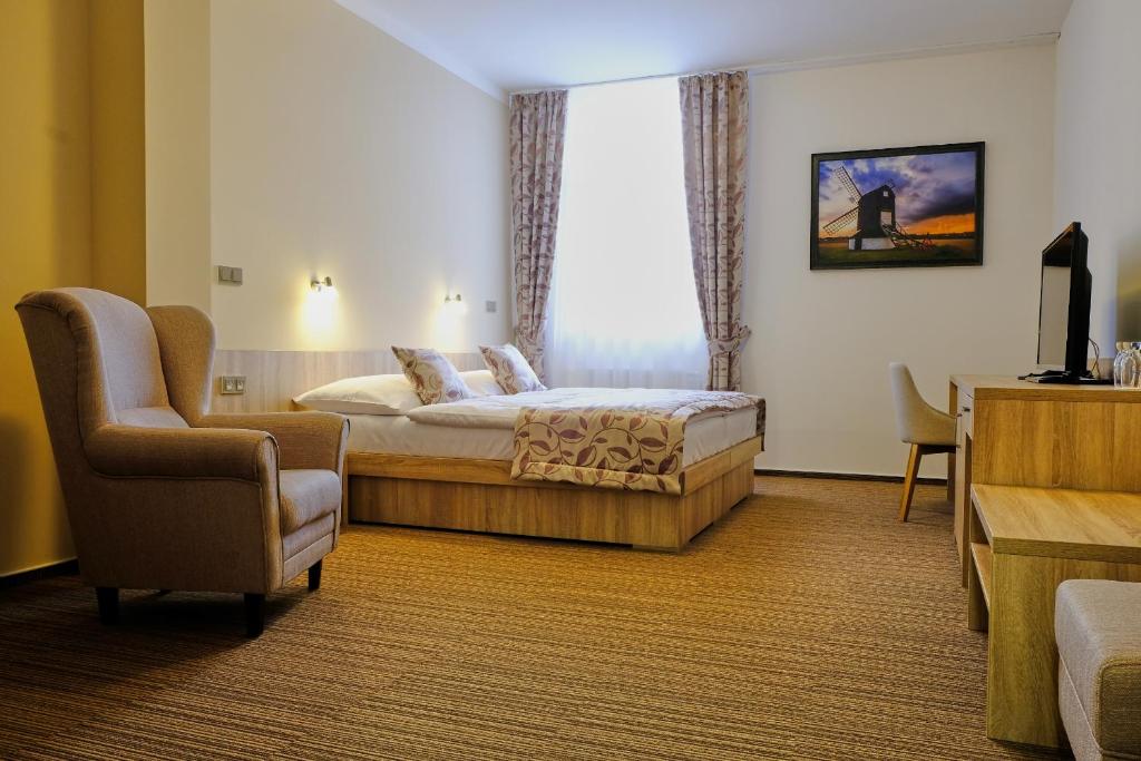 een hotelkamer met een bed en een stoel bij Hotel GTC 3* superior in Bílovec