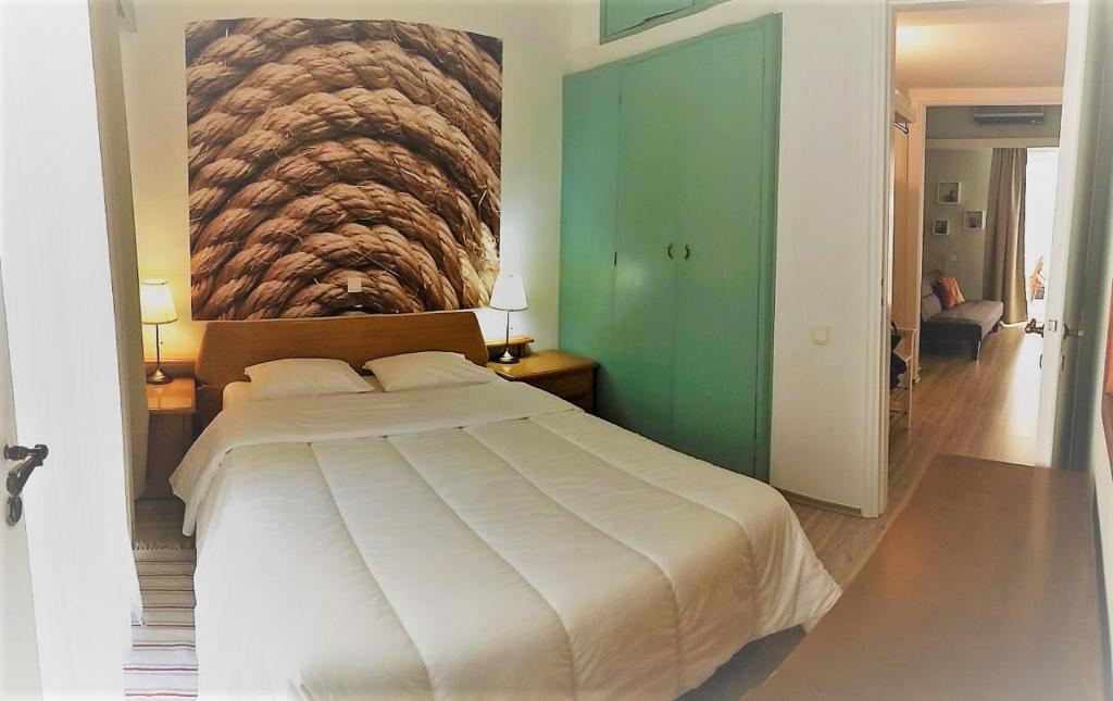 - une chambre avec un grand lit blanc orné d'une peinture murale dans l'établissement Flat31, à Athènes