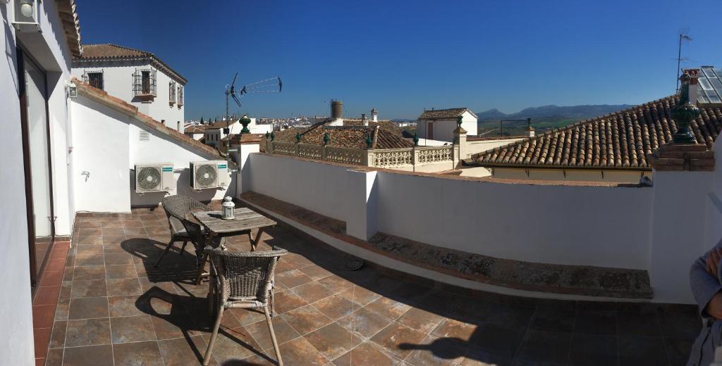 a balcony with a table and chairs on a roof at Casco Historico Apt. Doña Concha in Ronda