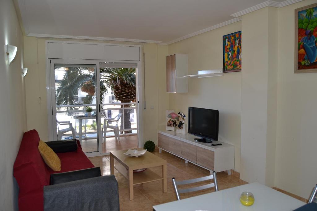 A television and/or entertainment centre at Luminoso y amplio apartamento en Salou con piscina