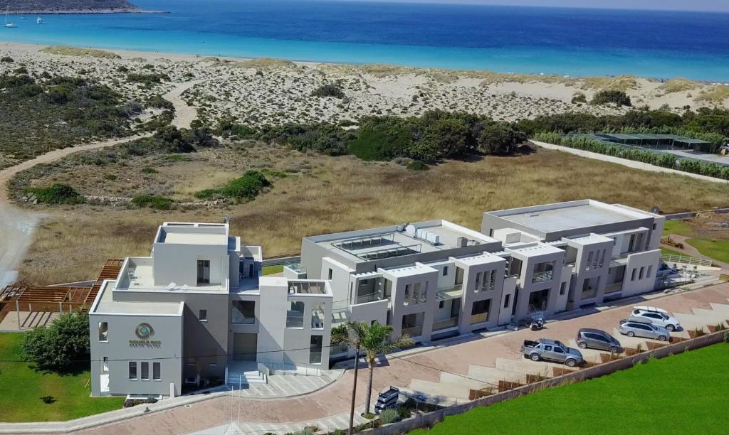 z góry widok na duży biały budynek z plażą w obiekcie Double Bay Beach Hotel w Elafónisos