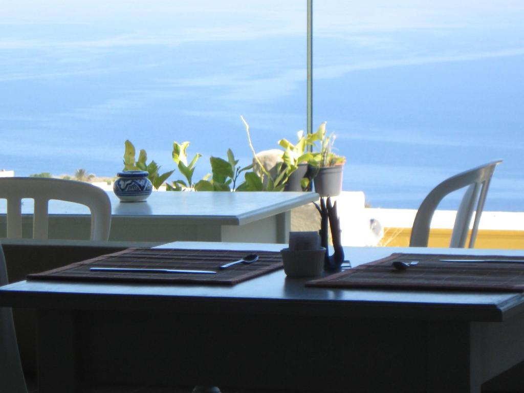 a table and chairs with a view of the ocean at Eoliano B&B in Malfa